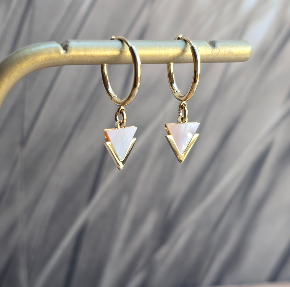 Boucles d'oreilles graphiques en acier inoxydable doré et nacre blanche, design minimaliste.