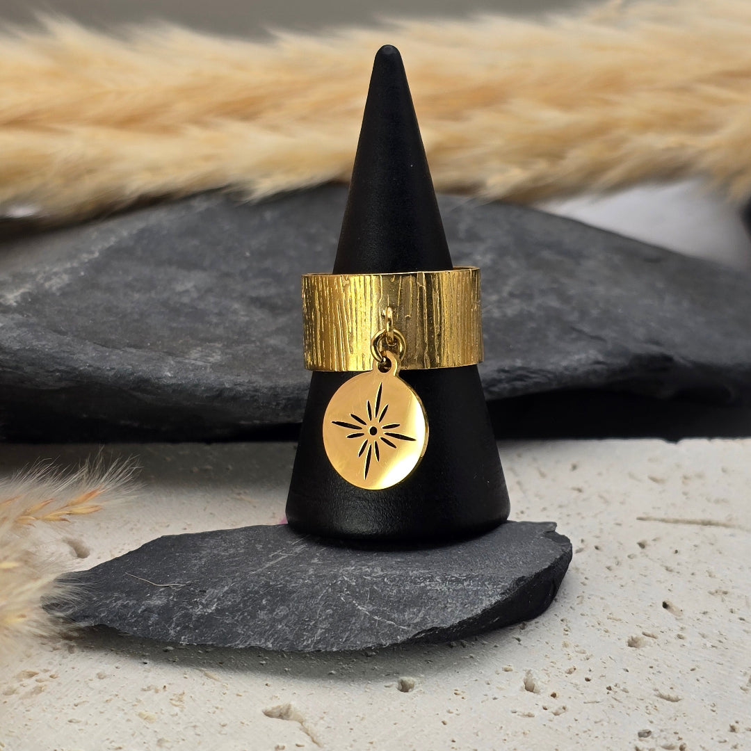 Détail de la bague Stella dorée avec médaillon breloque ajouré motif étoile