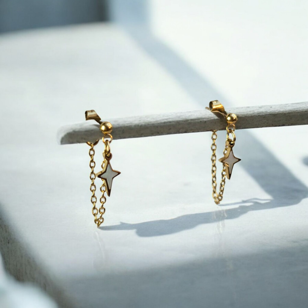 Boucles d’oreilles Adara avec clou doré, chaîne fine et pendentif étoile blanche, fait main en Haute-Savoie (Cruseilles).