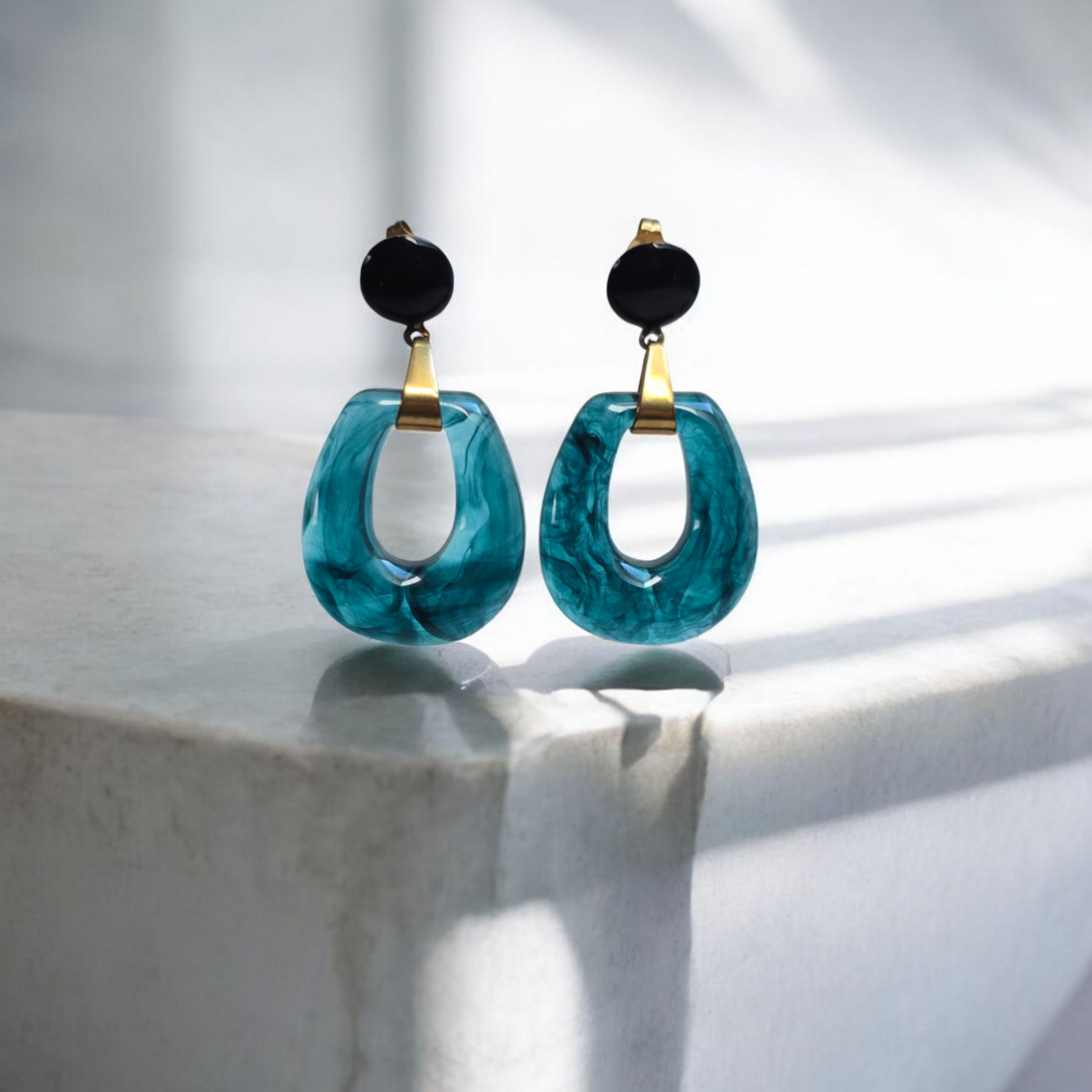 Boucles d’oreilles Cirelia en résine bleu transparent, attache noire émaillée, création artisanale en Haute-Savoie (Cruseilles)