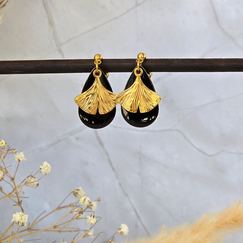 Boucles d’oreilles noires et dorées Decima longueur 4 cm portées à l’oreille
