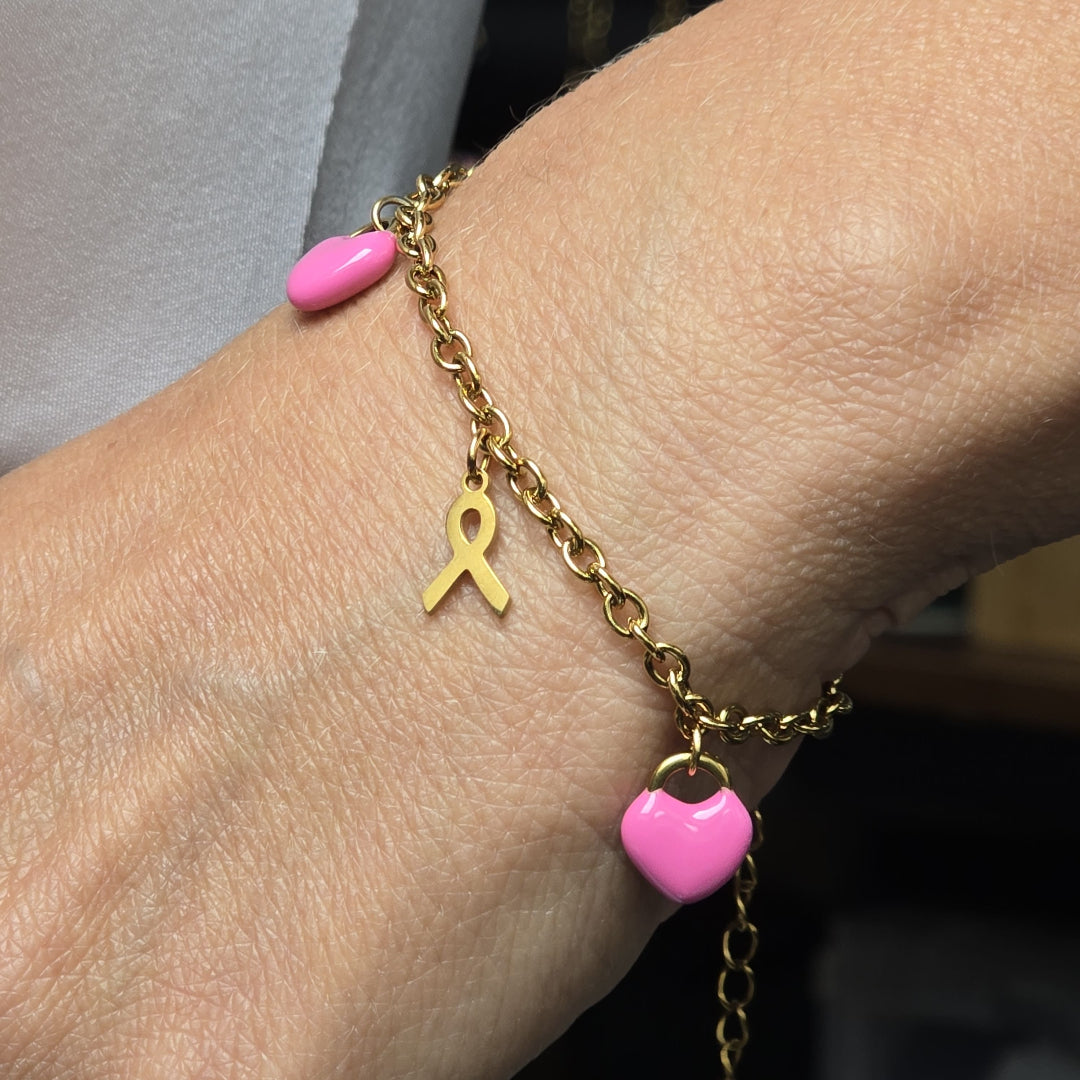 Bracelet doré porté avec breloques rose et ruban symbole Octobre Rose, bijou solidaire Zateka Création