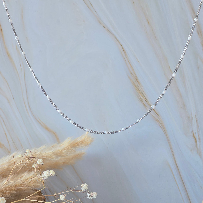 Collier ALBA en acier inoxydable argenté avec perles blanches porté autour du cou