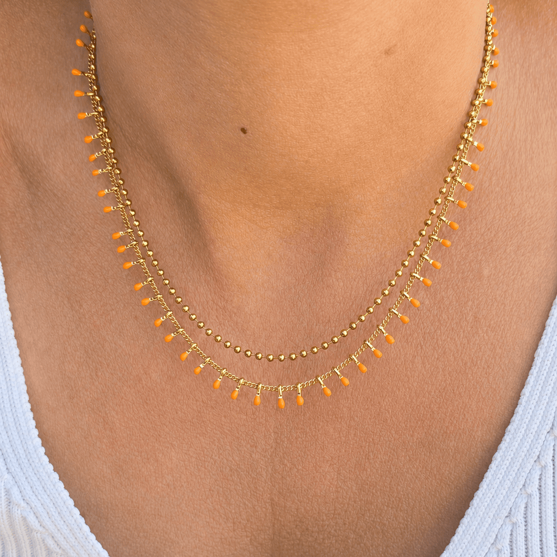 Collier femme à double chaîne avec gouttes corail pour un style estival.