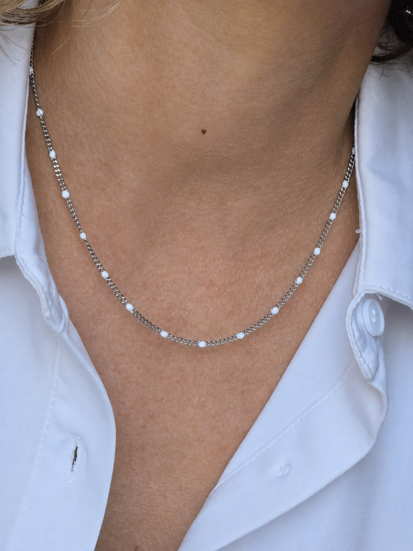 Collier argenté femme avec petites perles blanches porté avec une chemise blanche