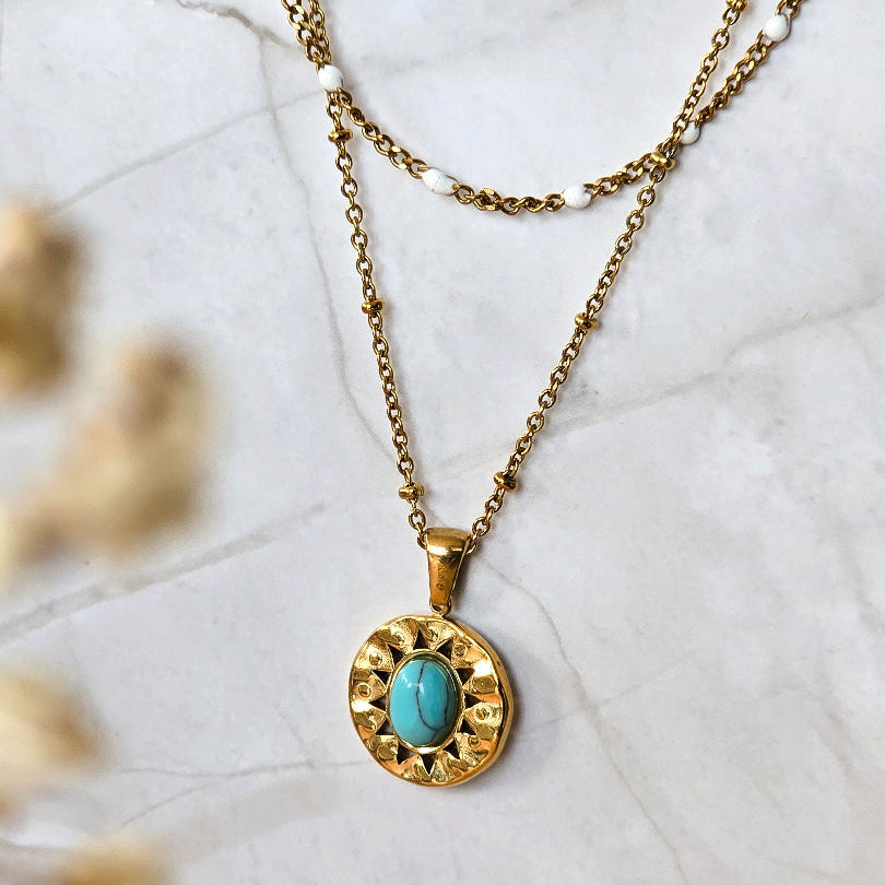 Détail du collier Damara avec chaîne fine perlée, perles blanches et pendentif turquoise