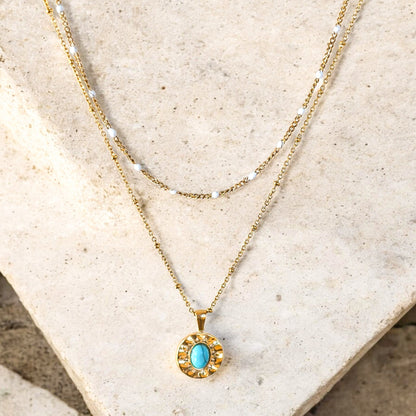 Collier Damara double rang doré avec chaîne perlée blanche et pendentif turquoise
