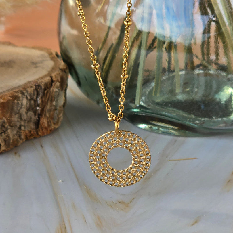 Collier doré ERIS avec pendentif rond ajouré et texturé
