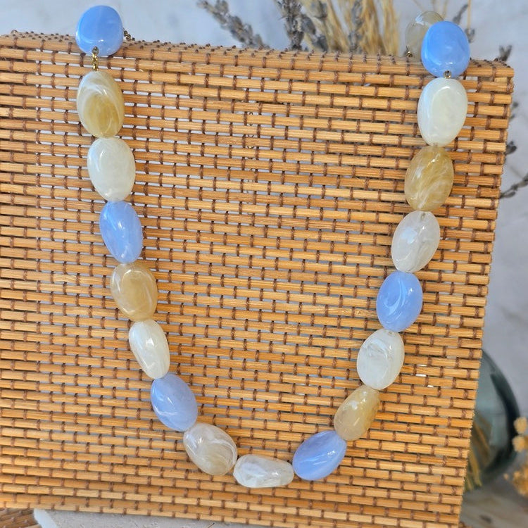 Collier tendance femme avec perles ovales effet résine, idéal pour une tenue estivale.