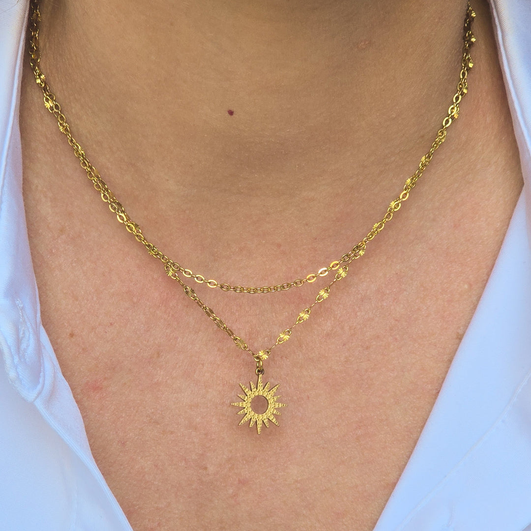 Collier Melia double rang doré porté au cou avec pendentif soleil