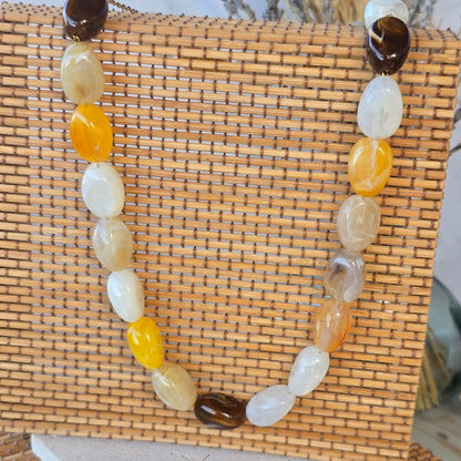Collier orange doux, marron et crème pour une silhouette lumineuse et tendance.