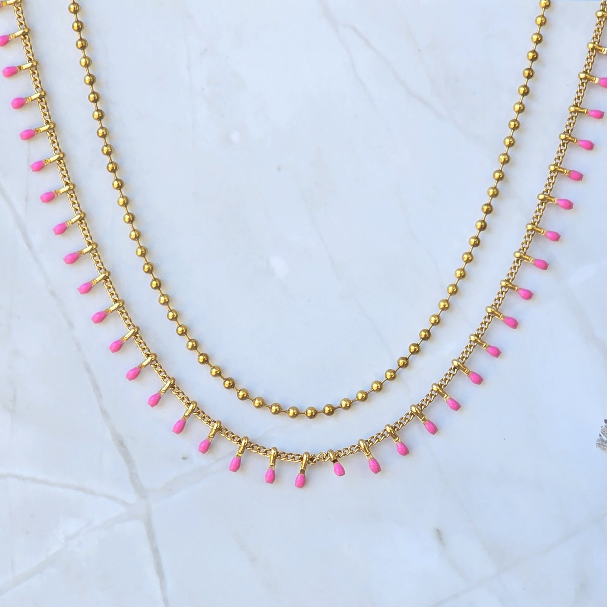 Collier double rang rose fuchsia en acier inoxydable doré.