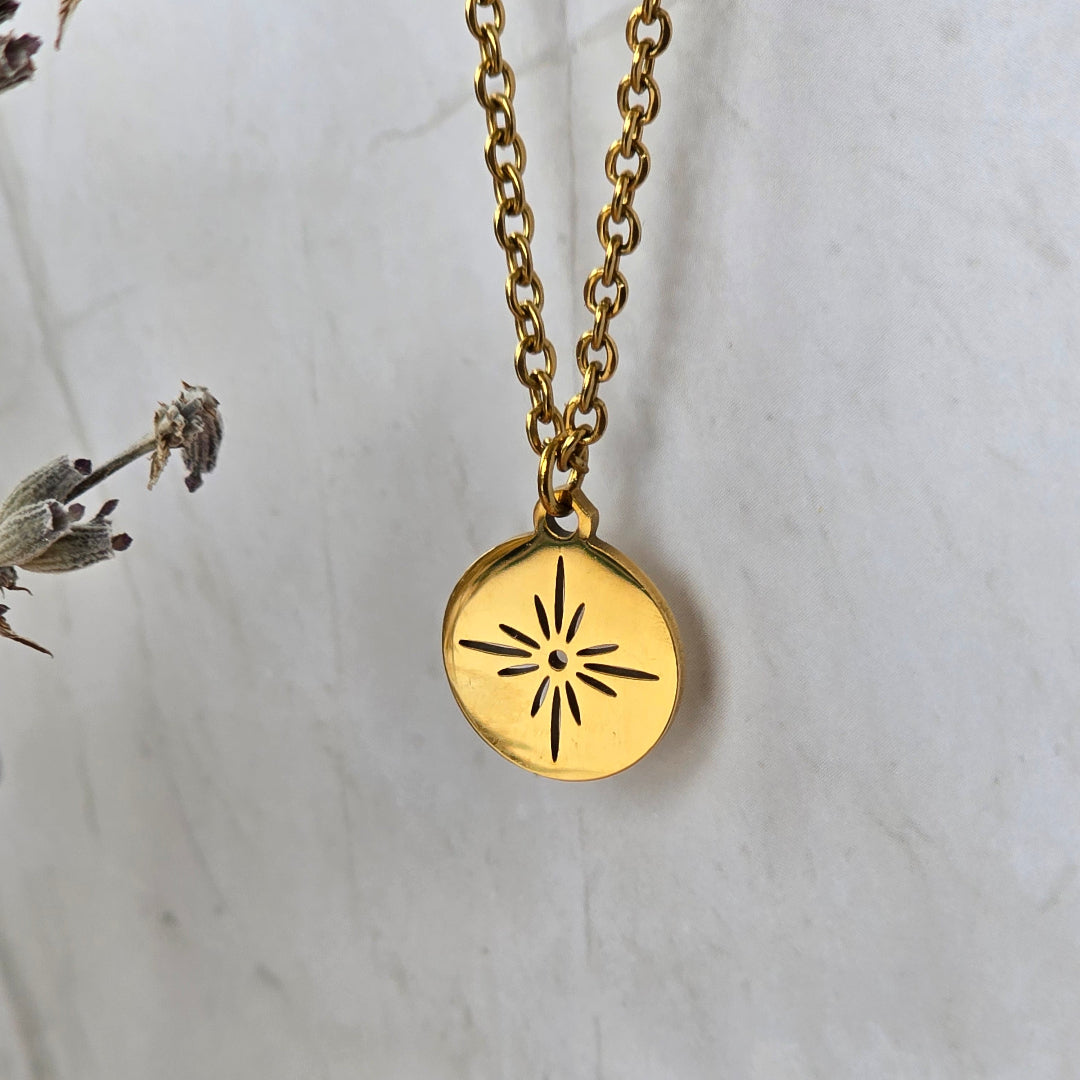 Détail du collier Stella doré avec médaillon rond motif solaire