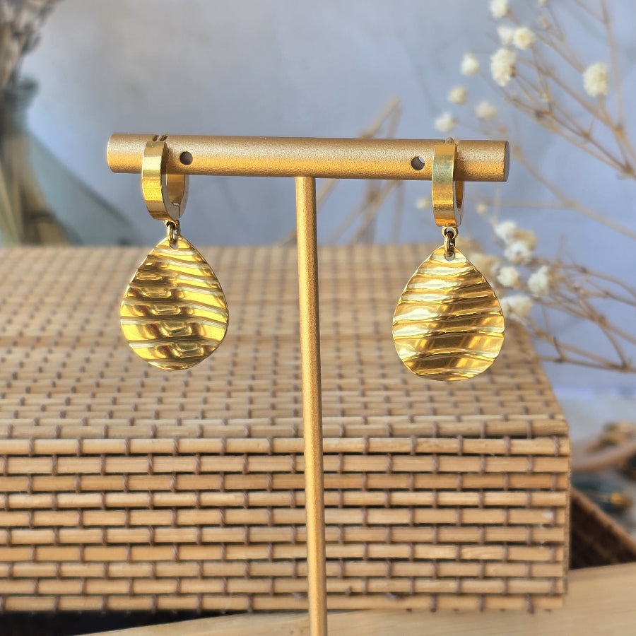 Créoles en acier inoxydable doré avec pendentif goutte texturée.
