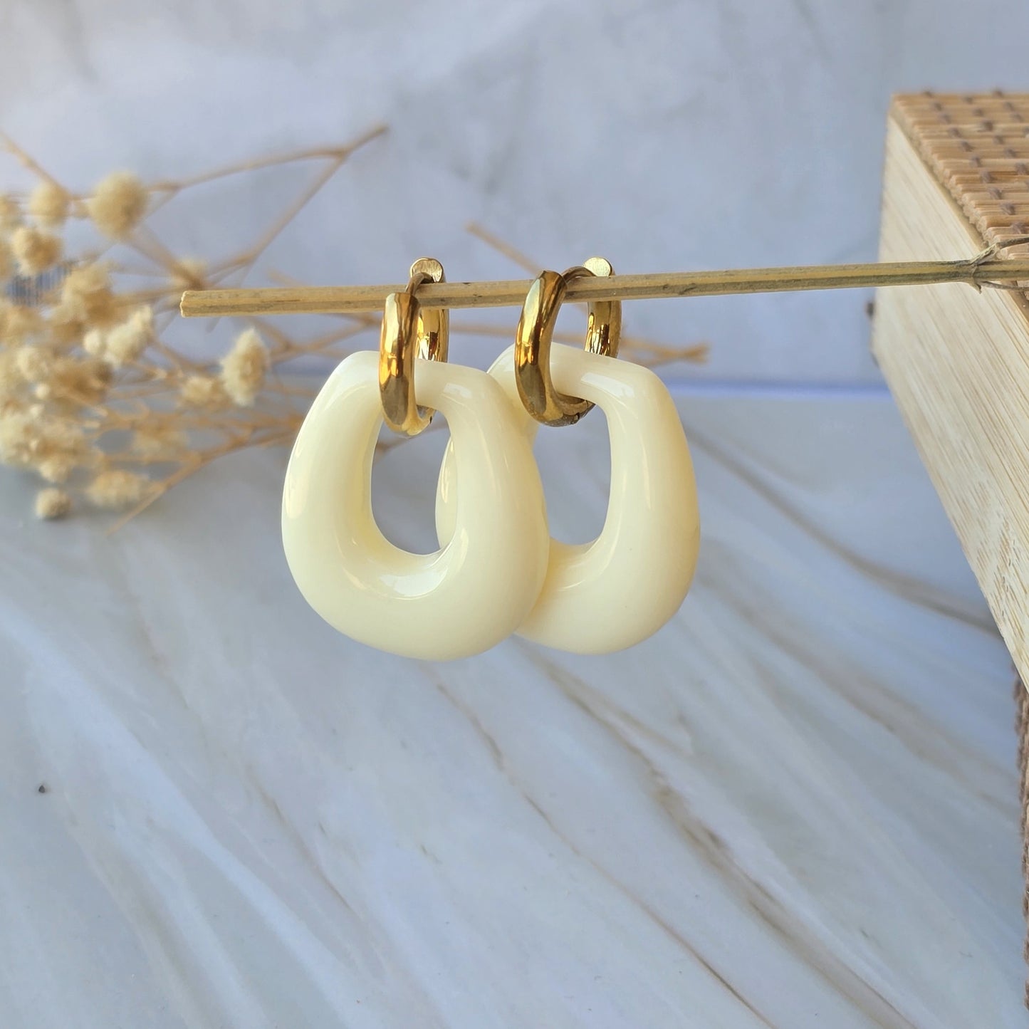 Boucles d'oreilles créoles avec pendentif crème effet marbré.