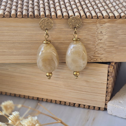 Puces d'oreilles crème marbré au style lumineux et intemporel.