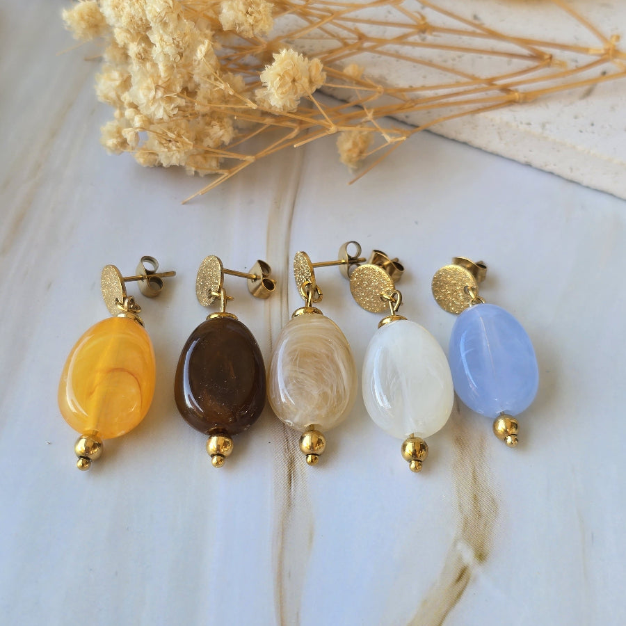 Puces d'oreilles femme en acier inoxydable doré avec perles ovales marbrées de la collection MIRA.
